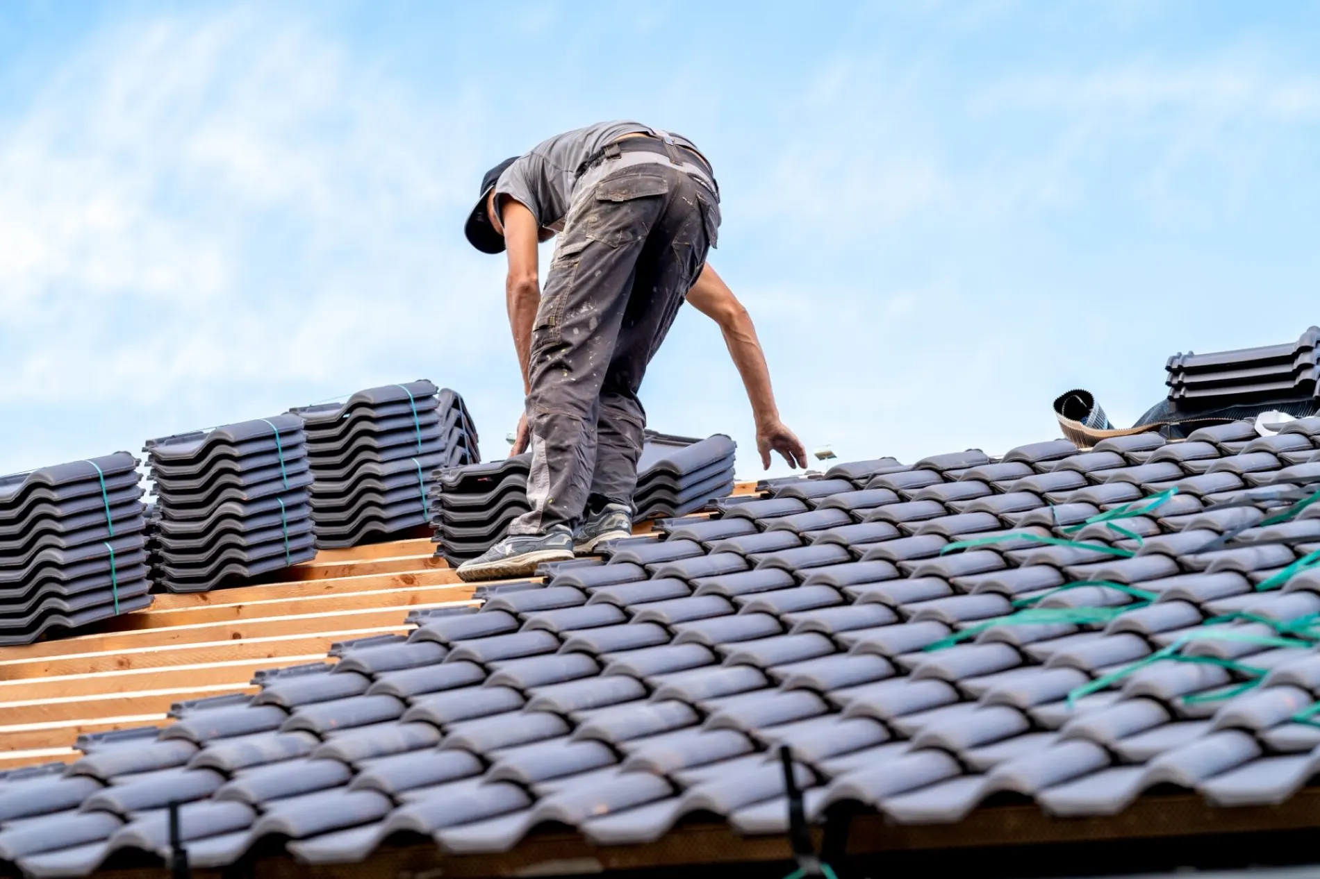 Roofer laying new tiles on a roof