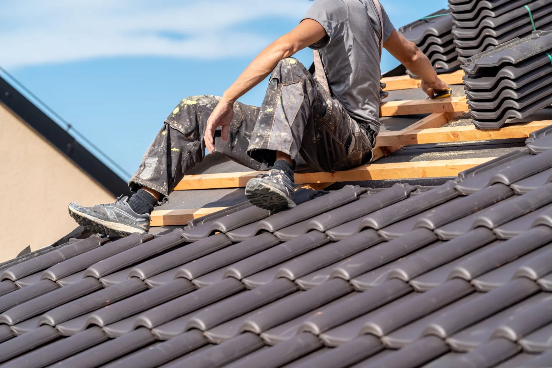 Roofer laying new roof tiles